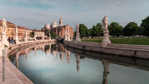 Historic center of the ancient Italian city Padua in Veneto. The famous Prato della Valle with water and statues, View on the Abbey of Santa Giustina. Time-lapse during the sunset. photo