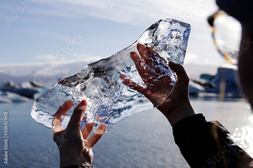 Vászonkép Woman holding piece of glacier in lagoon, Iceland