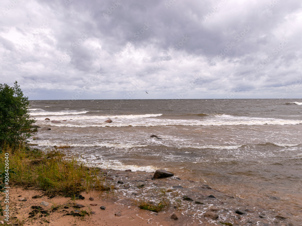 blurred foreground with sparkling waves, clouds and sea in the background