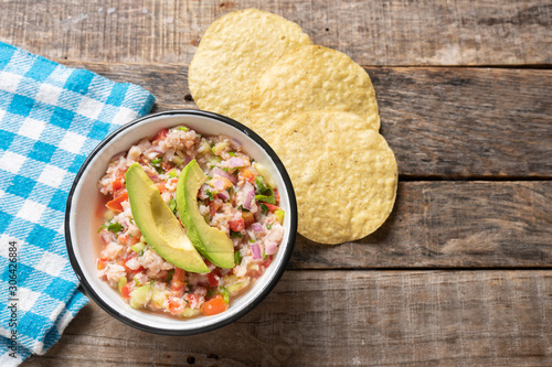 Mexican fish  ceviche with avocado on wooden background