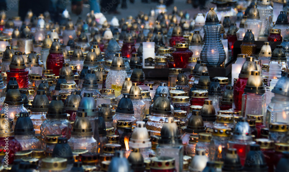 Monument and candles in the cemetery. All Saints Day in Poland. A lot of funeral candles.