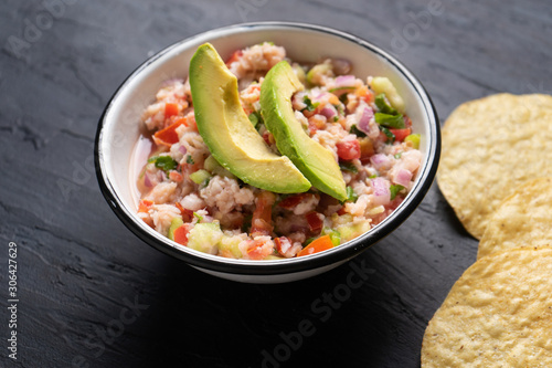 Mexican fish  ceviche with avocado on dark background photo