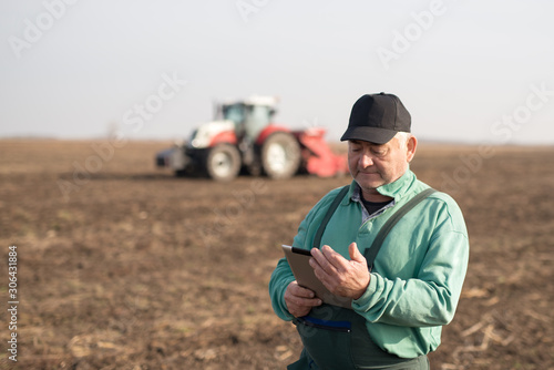 Canvas Print Modern senior farmer using tablet on the field