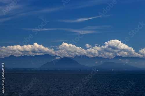 White clouds over the blue mountains on the Pacific Ocean, BC, Canada