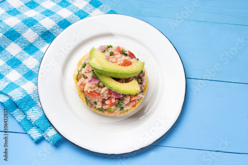 Mexican fish  ceviche with avocado on blue background