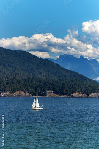 Sail boat drifting towards the island on the Pacific Ocean, BC, Canada