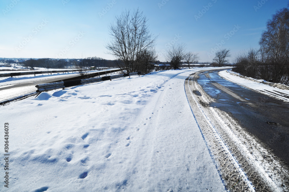 Winter countryside road with snow against blue sky Winter countryside road with snow against blue sky