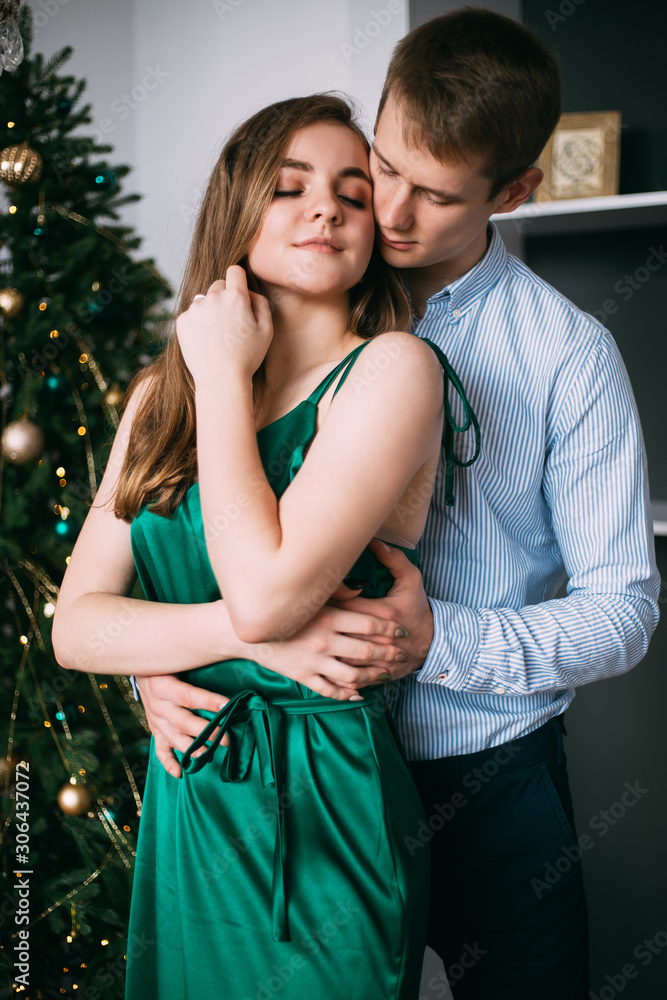 Close up of couple near a Christmas tree at home. New Year
