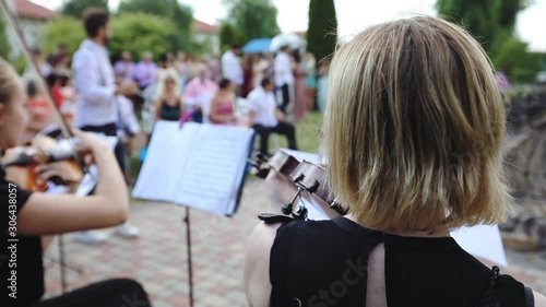 Young female musician violinists plays violin, wedding ceremony background