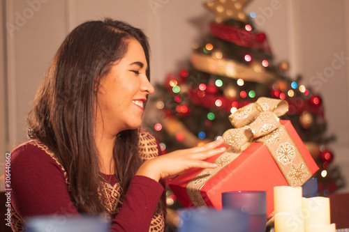 Chica con regalo y árbol de navidad esperando las fiestas photo