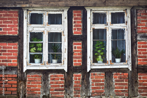 Wooden windows and half-timbered wall of a rural cottage in Poland.