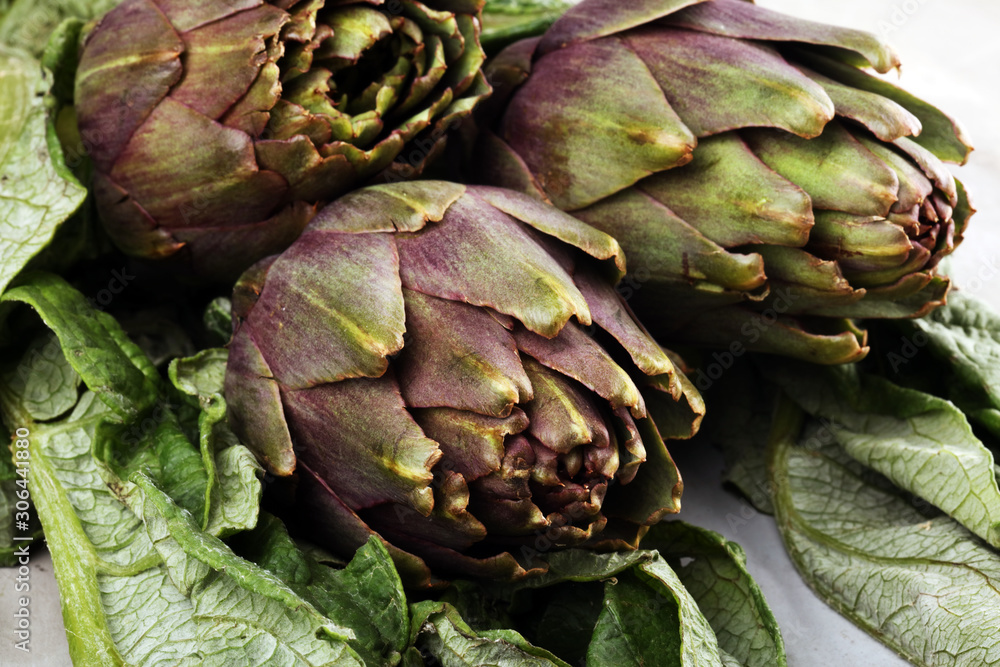 Fototapeta premium artichokes on grey background. fresh raw organic artichoke flower.
