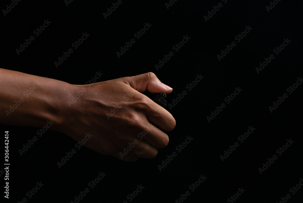 Hand holding burning gas lighters on dark background, Portable device used to create a flame, Close up Hand holding burning gas lighters on dark background, Portable device used to create a flame, Close up
