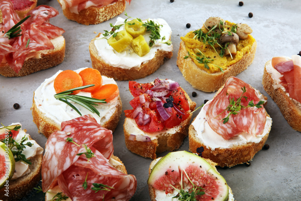 Assorted bruschetta with various toppings. Appetizing bruschetta or brie crostini. Variety of small sandwiches. Mix bruschetta on table
