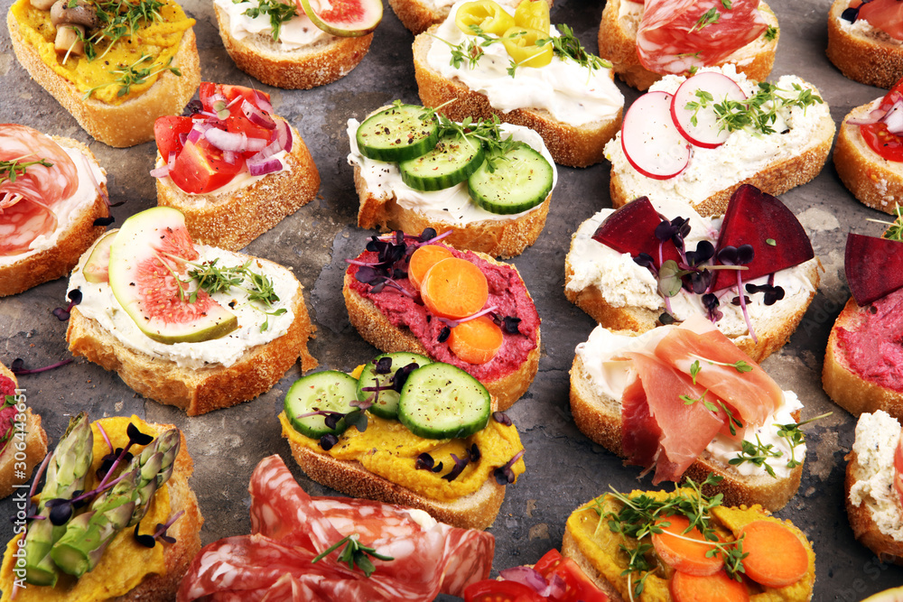 Assorted bruschetta with various toppings. Appetizing bruschetta or brie crostini. Variety of small sandwiches. Mix bruschetta on table Assorted bruschetta with various toppings. Appetizing bruschetta or brie crostini. Variety of small sandwiches. Mix bruschetta on table