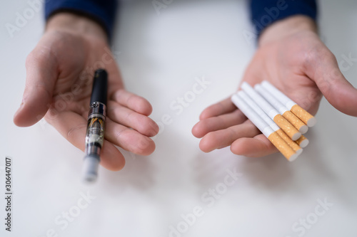 Man Holding Vape And Tobacco Cigarettes
