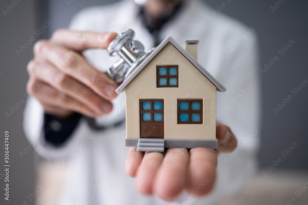 Doctor Holding Stethoscope On House Model Doctor Holding Stethoscope On House Model