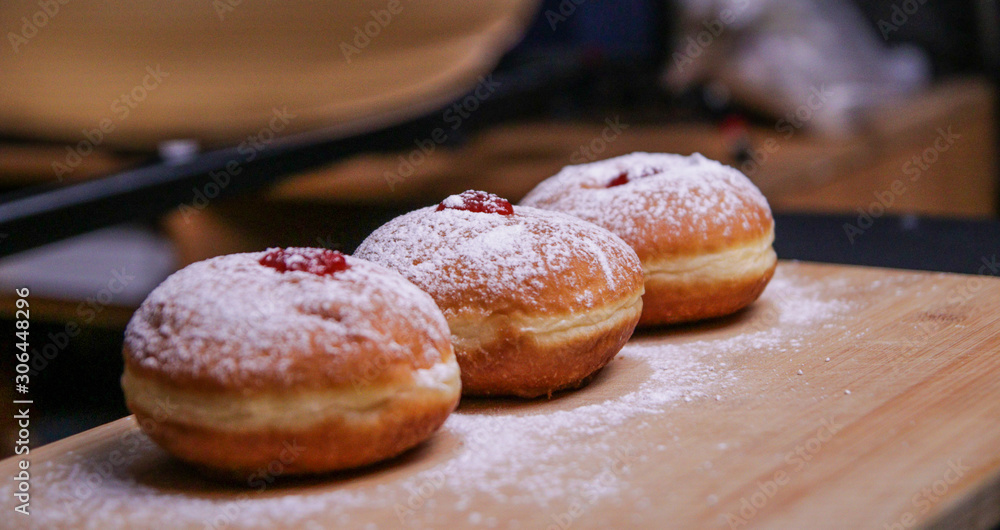 Hanukkah food doughnuts with jelly and sugar powder with bookeh background. Jewish holiday Hanukkah concept and background. Copy space for text. Shallow DOF