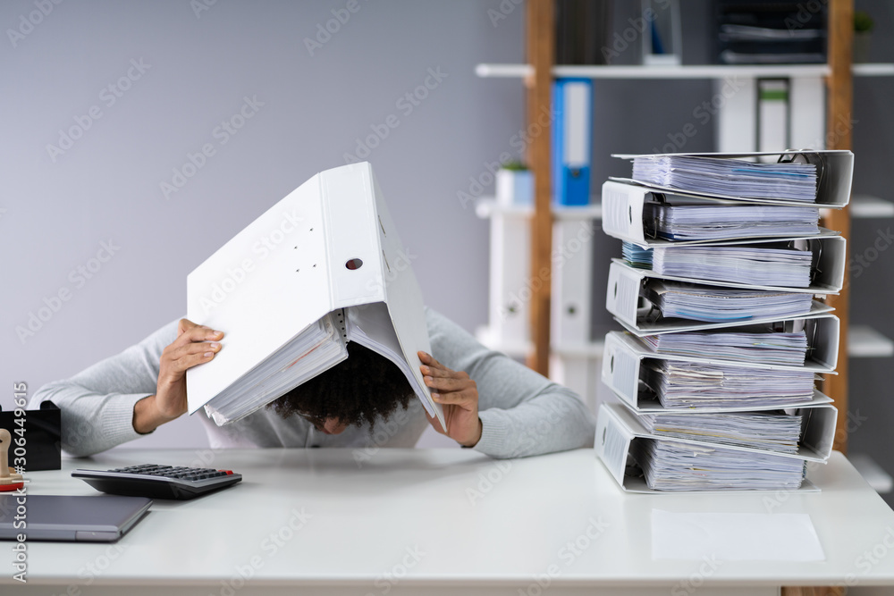 Businessman Hiding Under Folder In Office Businessman Hiding Under Folder In Office