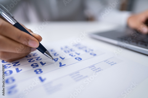 Businessperson Marking With Pen On Calendar