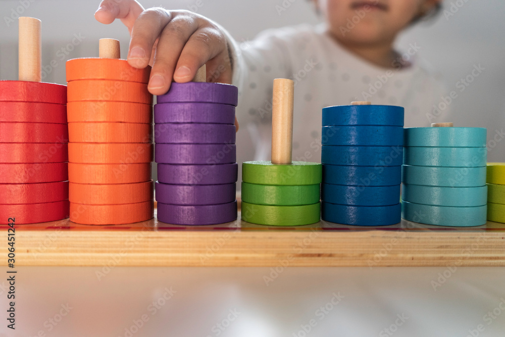girl playing with colored pieces the pieces are made of wood and ecological painting girl playing with colored pieces the pieces are made of wood and ecological painting