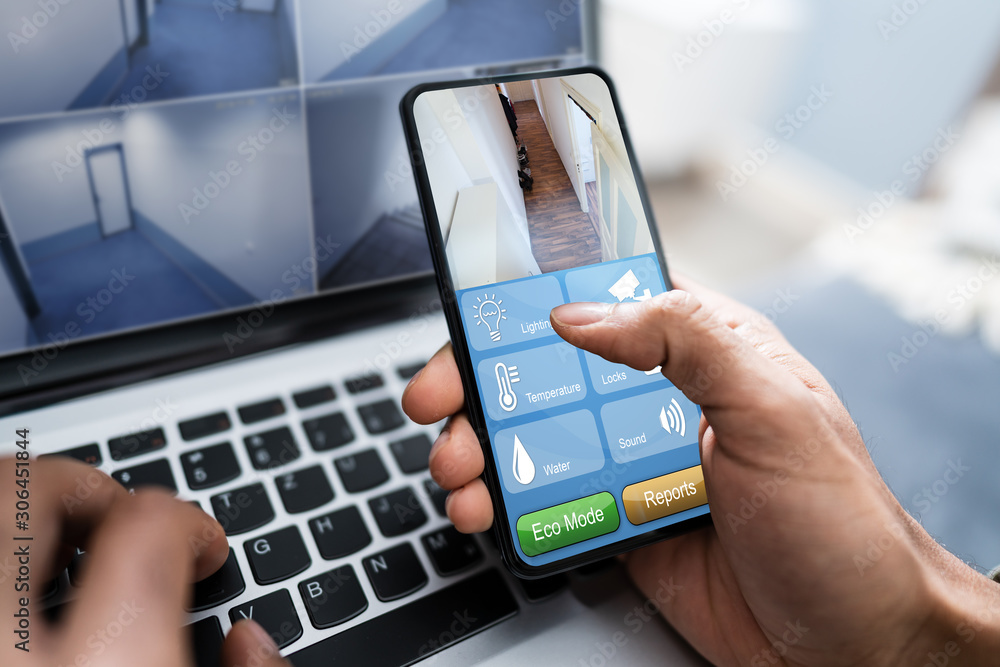 Person Using Home Security System On Mobile Phone Person Using Home Security System On Mobile Phone