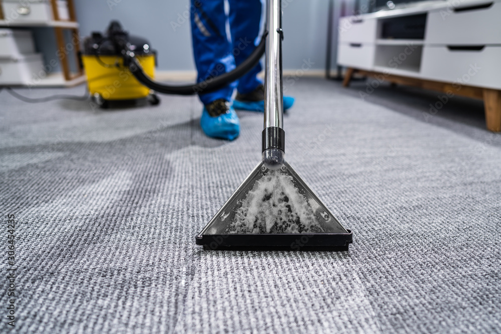 Fototapeta premium Person Cleaning Carpet With Vacuum Cleaner