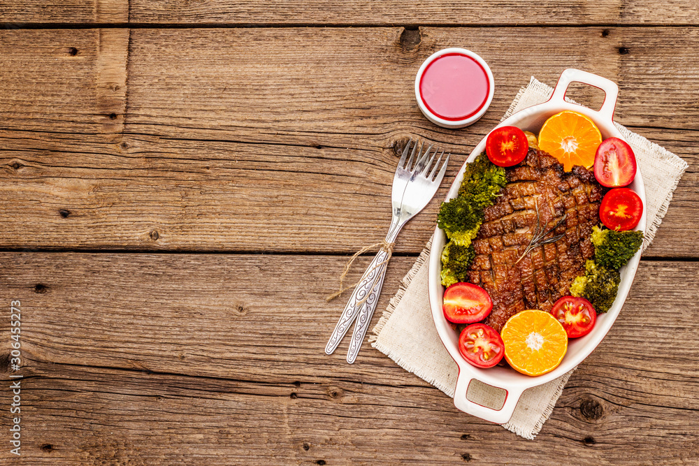 Baked duck breast on the bone with vegetables and sauce. Traditional healthy food concept. Vintage wooden boards background Baked duck breast on the bone with vegetables and sauce. Traditional healthy food concept. Vintage wooden boards background