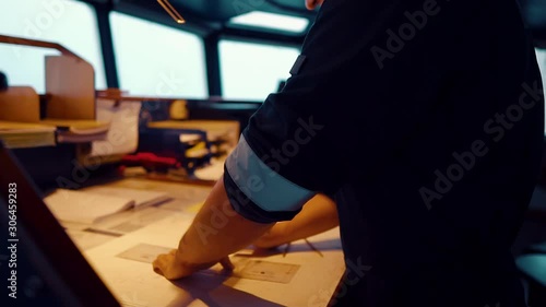 Marine navigational officer during navigational watch on Bridge . He does chart correction of nautical maps and publications. Work at sea photo