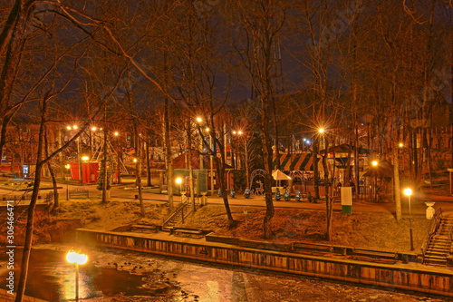 Smolensk, Russia, Pond with glowing streetlights, beautiful autumn evening in Park Lopatin Garden