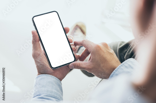 Mockup image blank white screen cell phone.men hand holding texting using mobile background empty space for advertise text.people contact marketing business and technology 