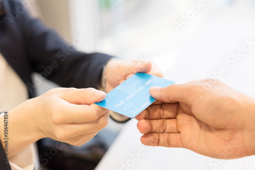 クレジットカードを店員に手渡す女性・パーツカット（決済・支払い・キャッシュレス）