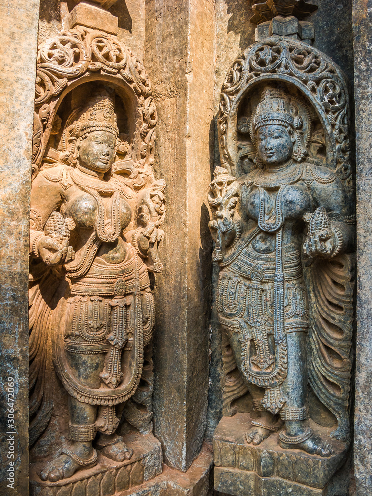 A pair of goddess sculptures on a temple wall.