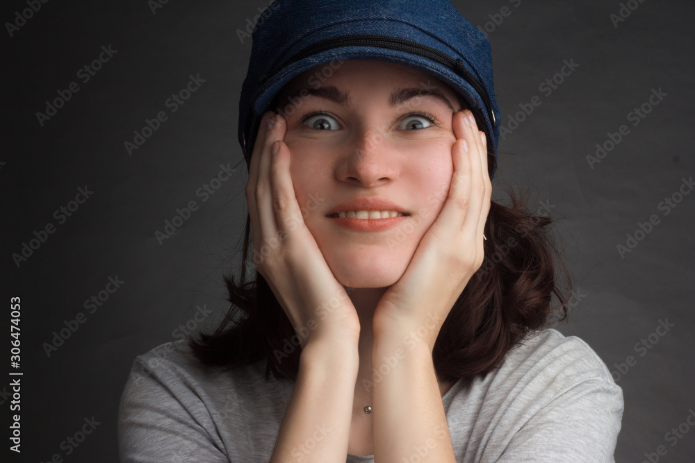 portrait of a brunette in a gray t-shirt and blue denim cap portrait of a brunette in a gray t-shirt and blue denim cap
