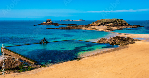 Fotografija Saint Malo in Brittany, France overlooking the beach, natural pool and fort islands on a sunny day with green waters and golden sand