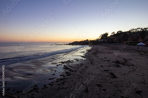 Sunset on Pacific Coast Beach with Silhouetted Trees and Structure