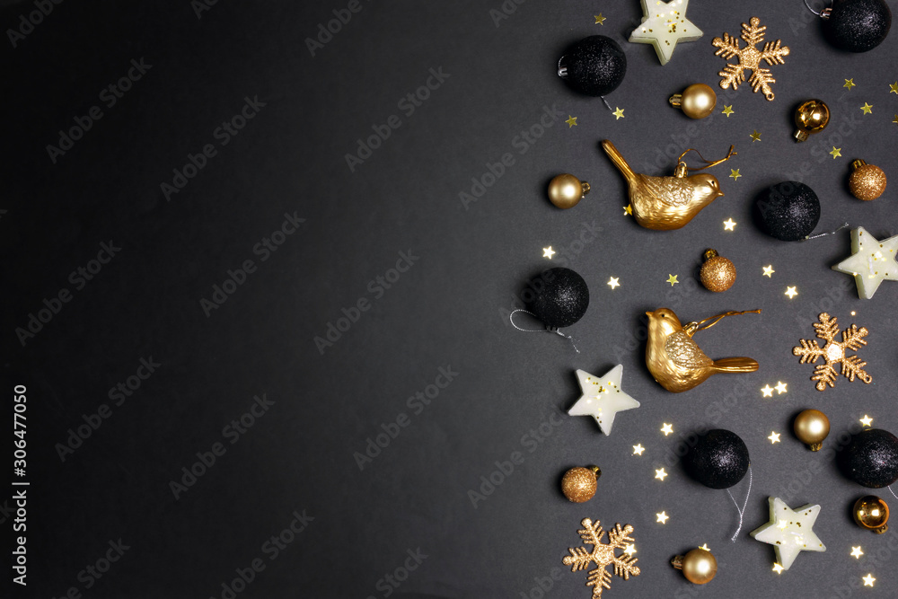 Fototapeta premium Golden Christmas decorations on back background with copy space for text. Composition of birds, candles stars, snowflakes and balls.
