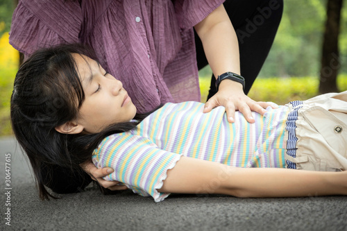 Schilderij op canvas Sick daughter is fainted and fallen on floor while playing and exercise,asian mo