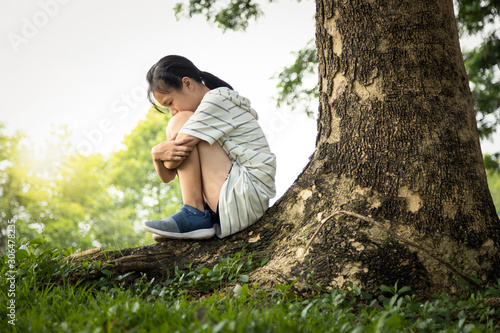 Fotografie Depressed asian child girl was sitting alone crying and thinking about problems