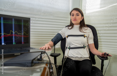 Fotografie woman in polygraph test with measuring devices to know the truth, scales, hoses