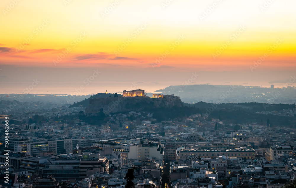 The Athens skyline, in Greece, in twilight. The Acropolis dominates the picture, while Filopappos Hill and the city of Piraeus are the background.