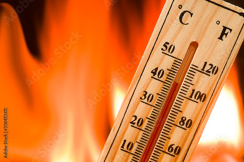 Climate change concept, wooden thermometer on flames background