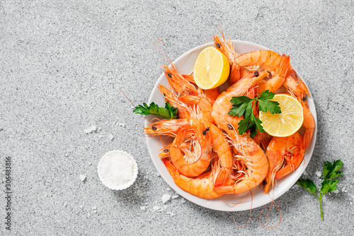 Steamed shrimps with lemon and herbs. Seafood, shellfish. Shrimps prawns on plate. photo