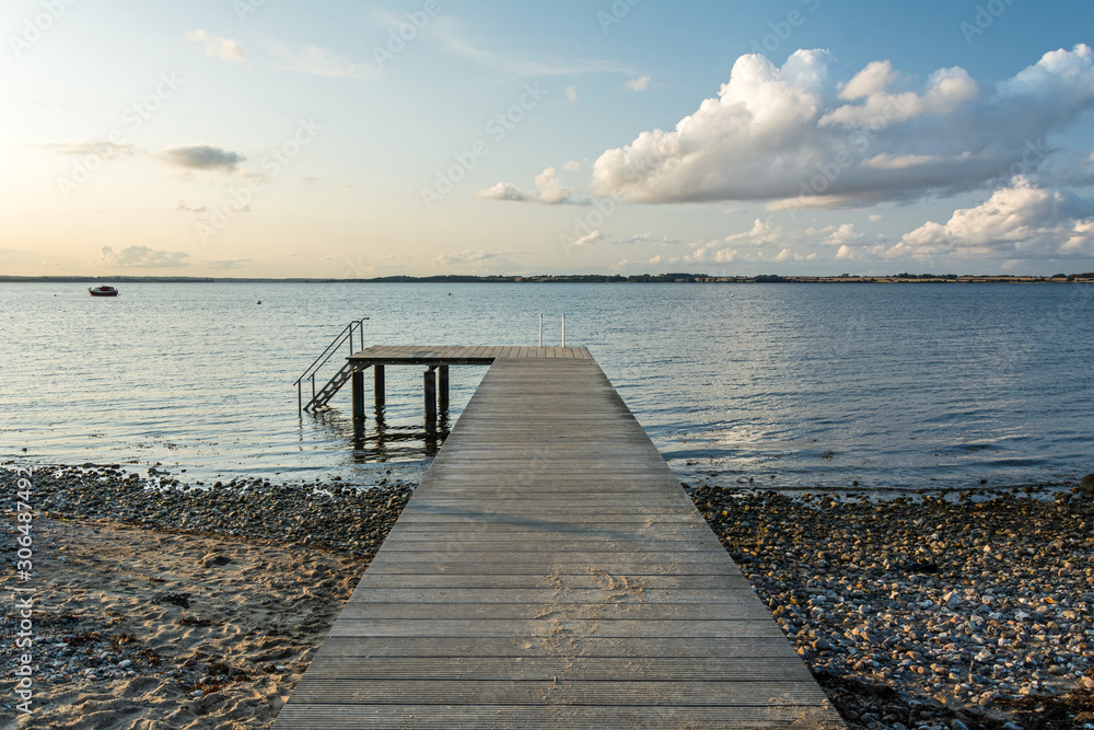 Wooden pier at the calm Baltic Sea in scenic evening light