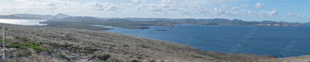 Côte rocheuse et îlot à proximité du cap et du phare de Cavallería, en arrière-plan le mont El Toro, Minorque, îles Baléares