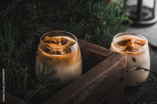 Iced coffee cocktail with milk on dark background