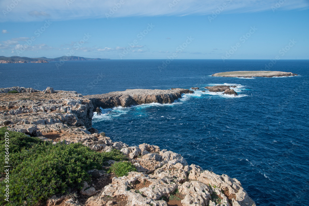Côte rocheuse et îlot à proximité du cap et du phare de Cavallería, Minorque, îles Baléares Côte rocheuse et îlot à proximité du cap et du phare de Cavallería, Minorque, îles Baléares