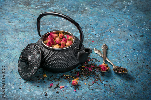 Black japanese cast iron teapot and flower tea with rose buds