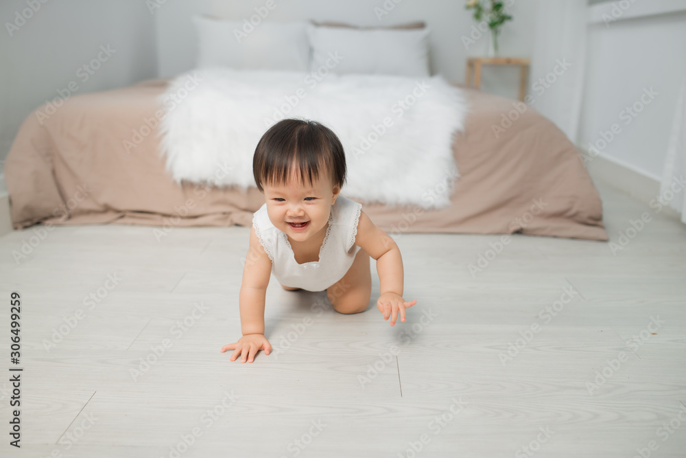 Little baby girl or girl crawling on floor in bed room Photos | Adobe Stock