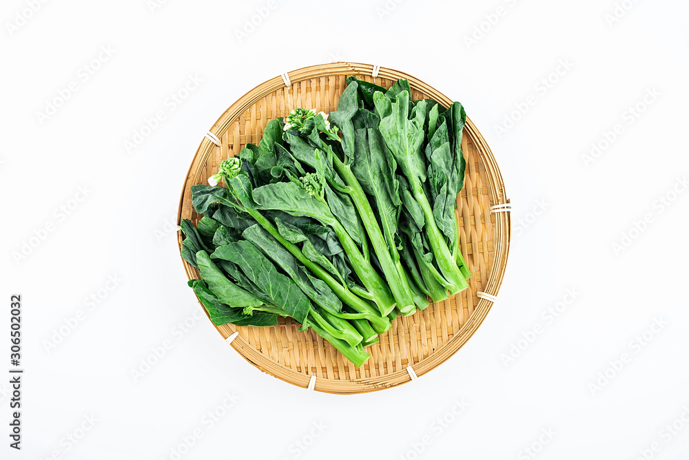 Bamboo sieve filled with fresh green vegetables kale hearts on white background Bamboo sieve filled with fresh green vegetables kale hearts on white background